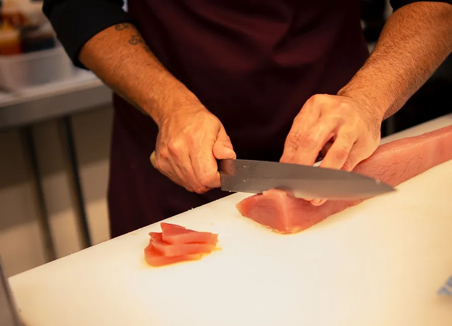 Preparo do sushi com corte do salmão fresco na cozinha do Vera Sushi Lounge